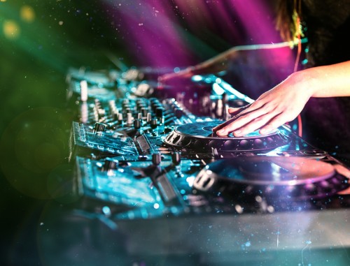 Dj mixes the track in the nightclub at a party, close-up.